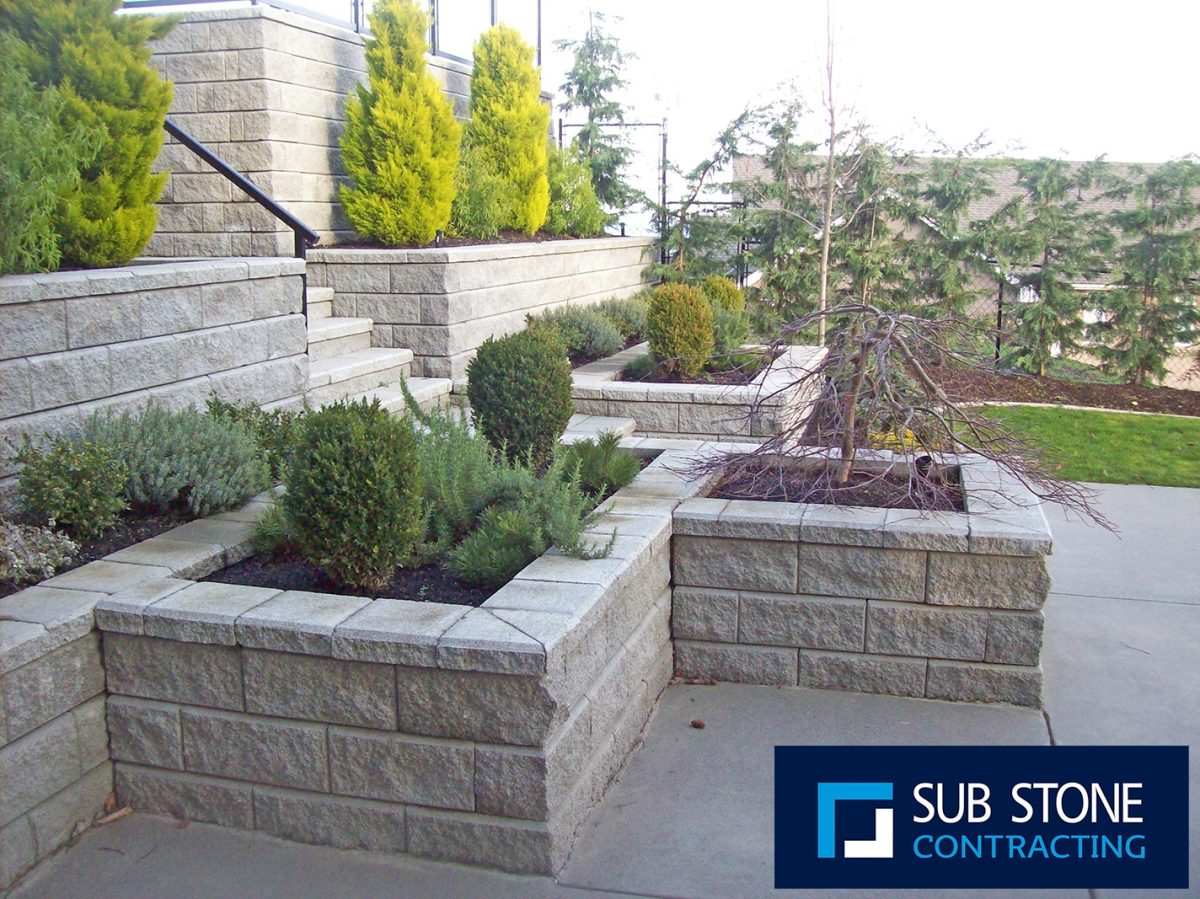 stone block planters with shrubs and bushes